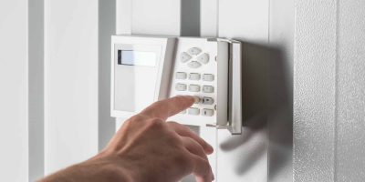 person-typing-on-keypad-of-home-security-alarm-security-system-concept.jpg